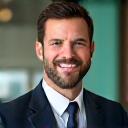 Portrait of Mark T., a business consultant, smiling confidently.