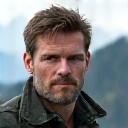 Portrait of Oliver K., an adventure blogger, with a slight stubble and an adventurous gaze.